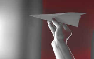 Papierflieger in Frauenhand